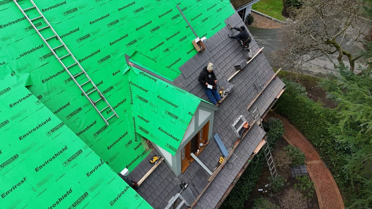 RR Roofing crew installing synthetic underlayment on a steep roof